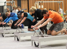 Men doing Pilates on reformers